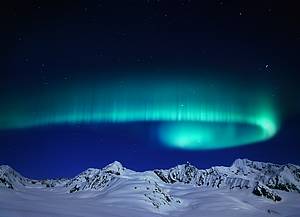 Une aurore boréale tournoyant à travers le ciel au-dessus de la chaîne montagneuse sur le glacier Canwell (Alaska)